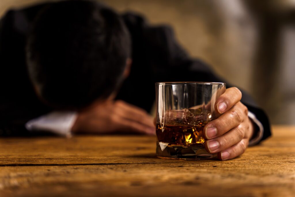 Alcoholismdepressedasianyoungmansleepontablewhiledrinking